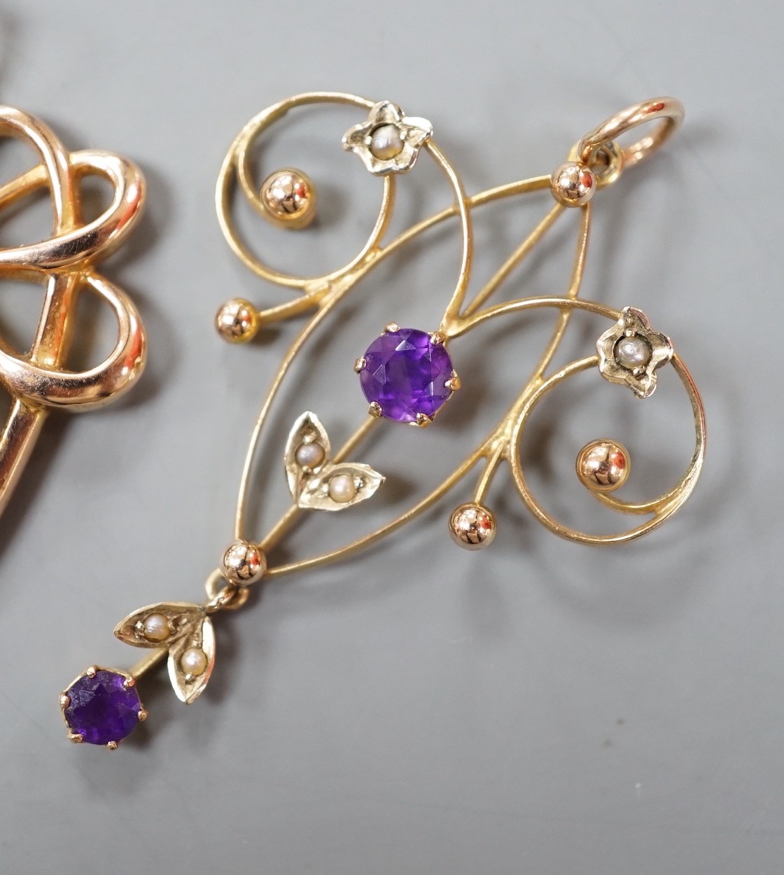 Three assorted early 20th century yellow metal and gem set pendants, including 9ct garnet and split pearl, largest overall 39mm, gross weight 5.2 grams.